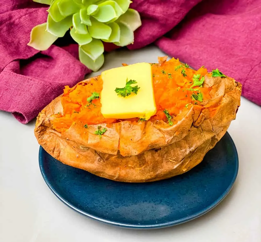 air fryer sweet potato on a blue plate with butter