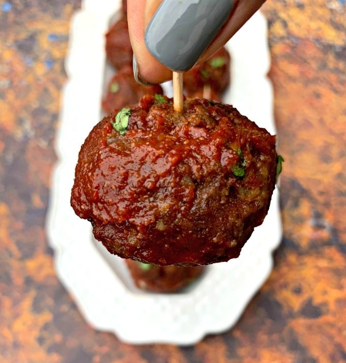 person holding keto low carb air fryer meatballs with bbq sauce