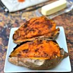 air fryer sweet potato with butter drizzled with honey on a blue plate