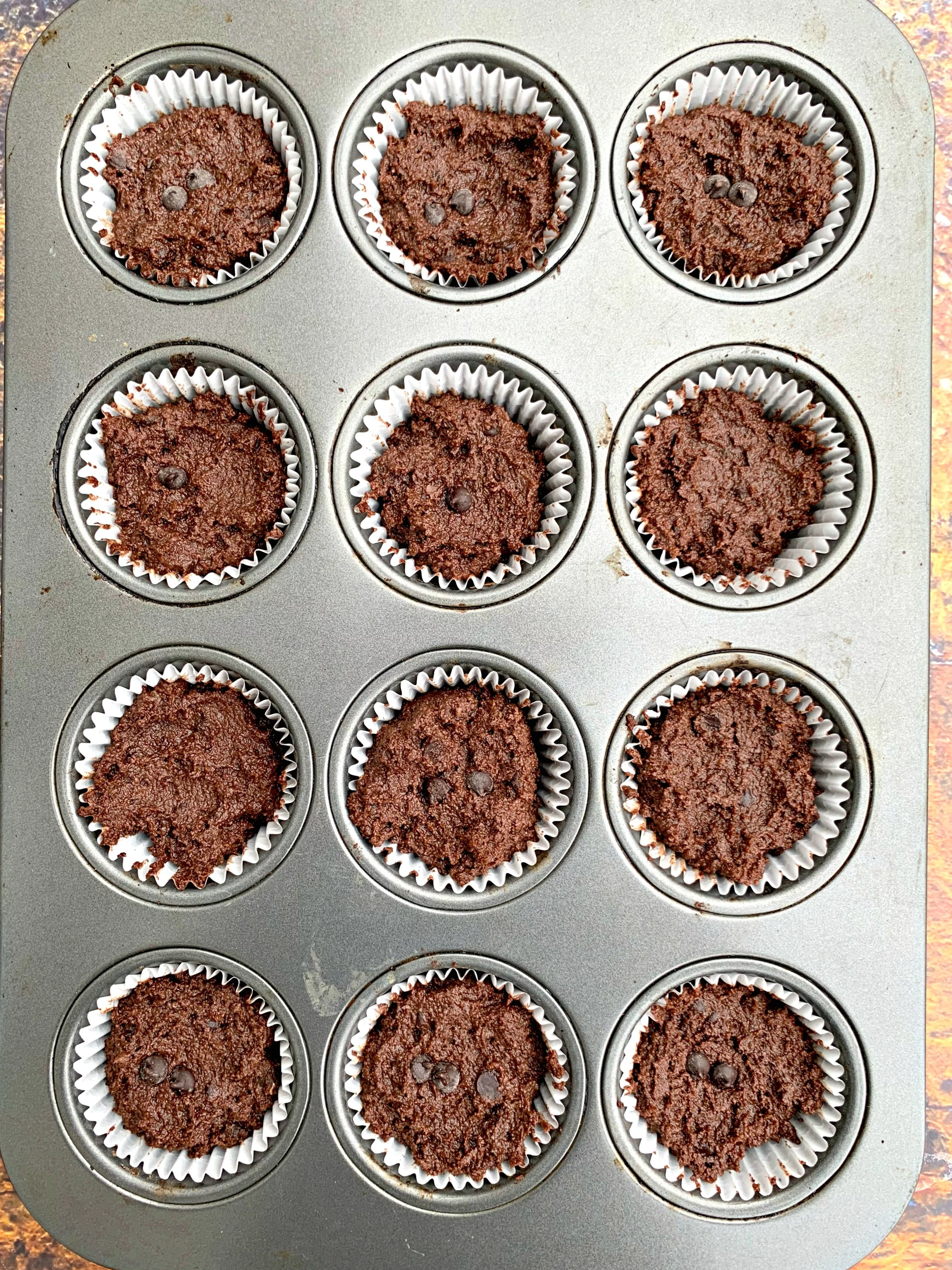 uncooked keto low carb chocolate muffins in a muffin tin