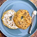 cooked keto fathead bagels on a blue plate with cream cheese