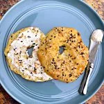 cooked keto fathead bagels on a blue plate with cream cheese