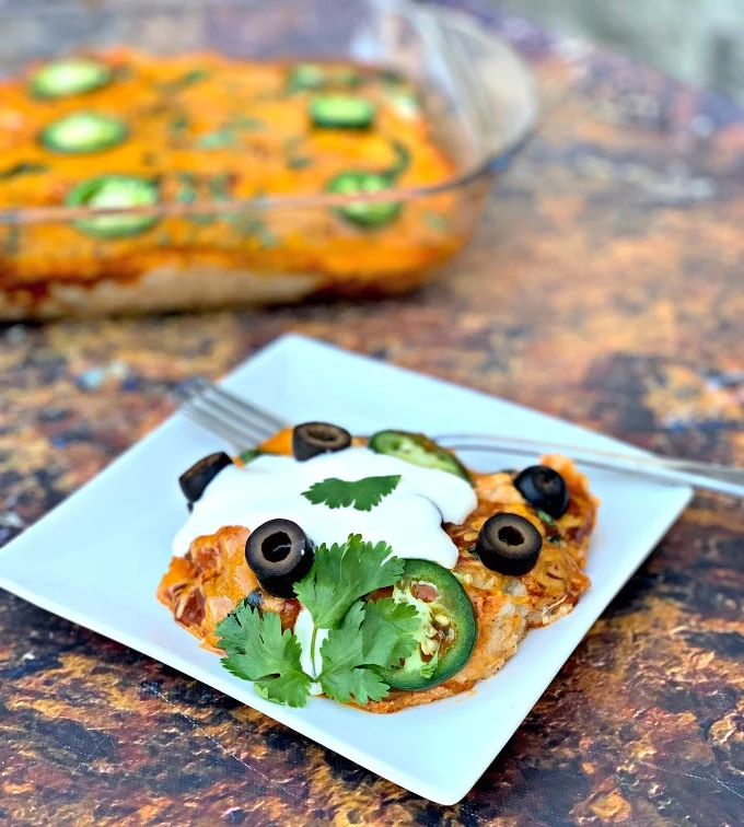 keto low carb enchilada casserole on a white plate and in a baking dish