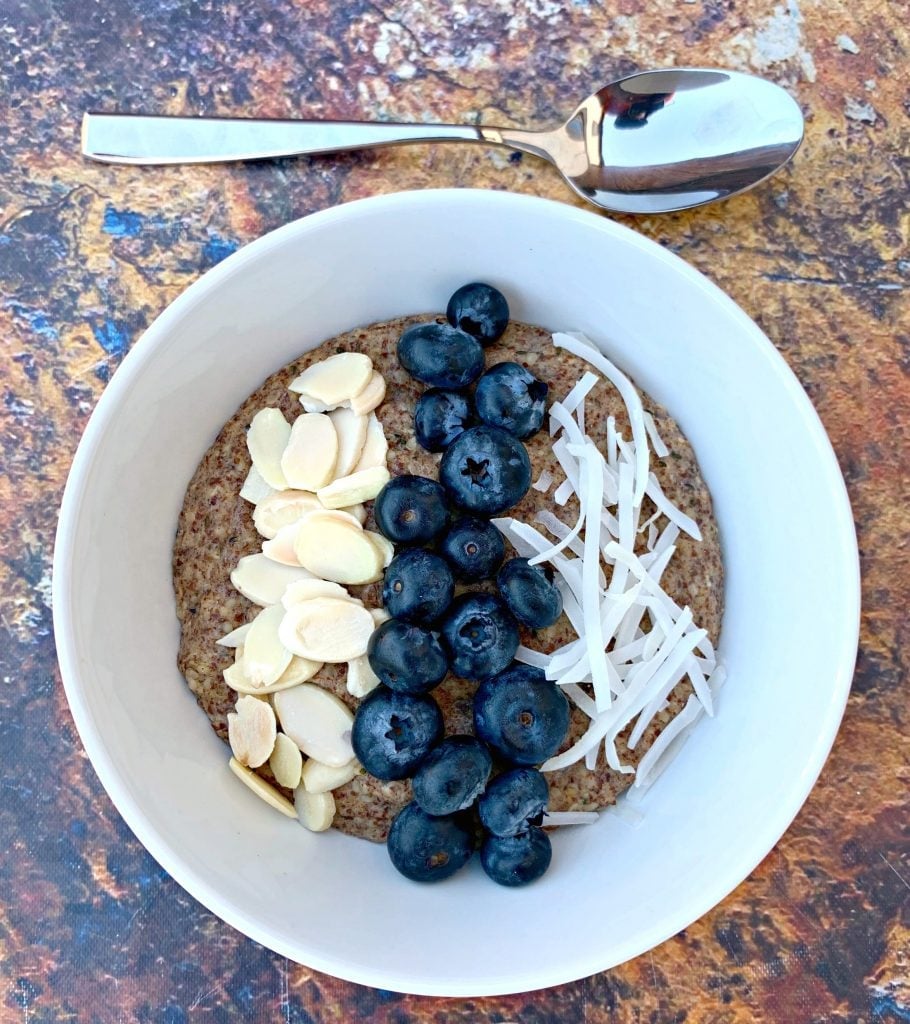 keto hemp oatmeal with blueberries, almonds, and coconut in a white bowl