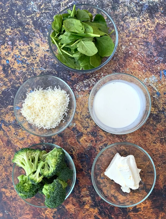 ingredients for keto chicken alfredo with broccoli and spinach in a skillet