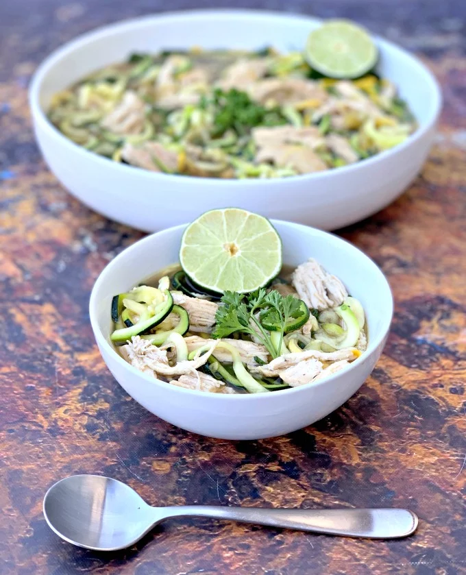 keto low carb chicken noodle soup with zucchini noodles in white bowls