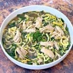 keto low carb chicken noodle soup with zucchini noodles in a white bowl