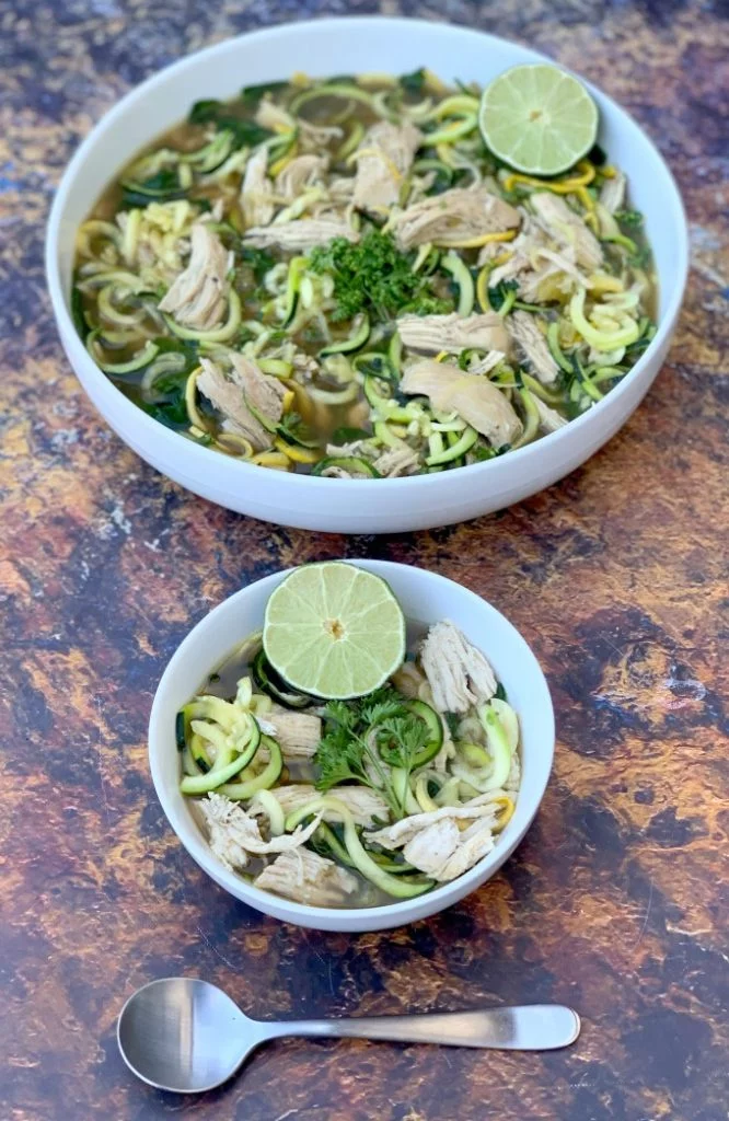keto low carb chicken noodle soup with zucchini noodles in white bowls