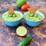 keto guacamole with low carb keto chips in blue bowls with fresh vegetables
