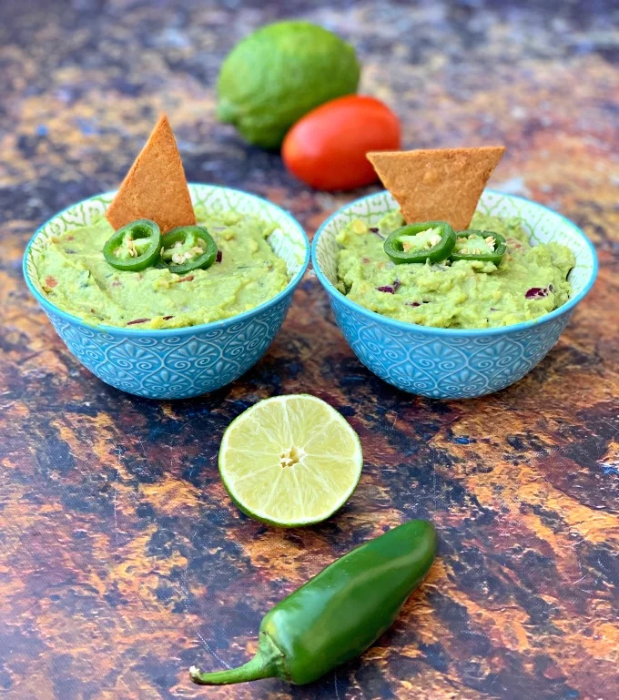 keto guacamole with low carb keto chips in blue bowls with fresh vegetables