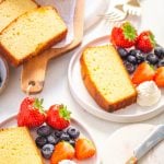 keto pound cake with whipped cream and strawberries on a white plate