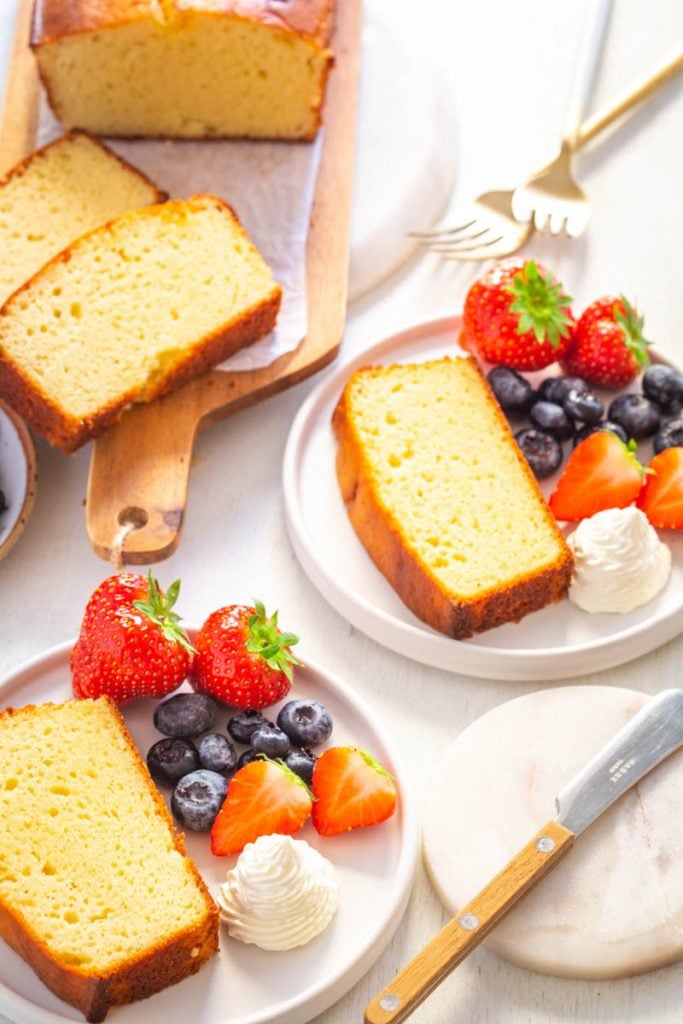 keto pound cake with whipped cream and strawberries on a white plate