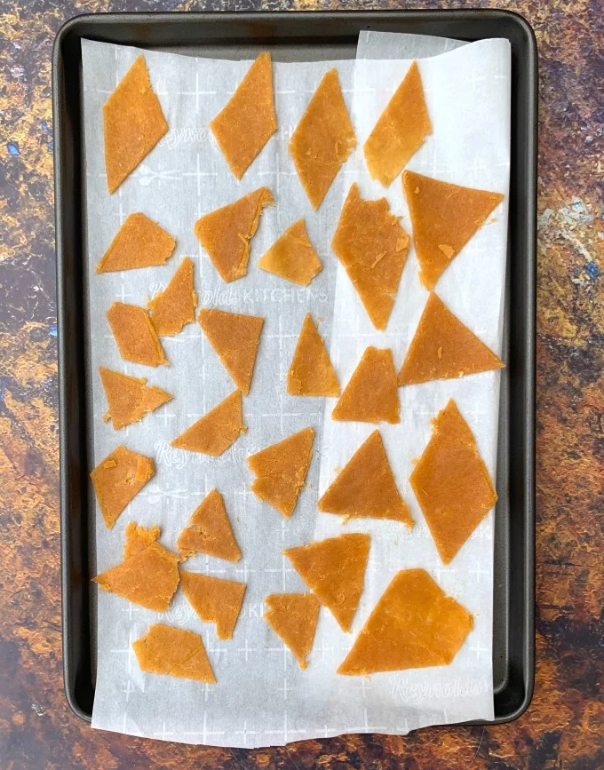 keto tortilla chips dough sliced in triangles on a sheet pan