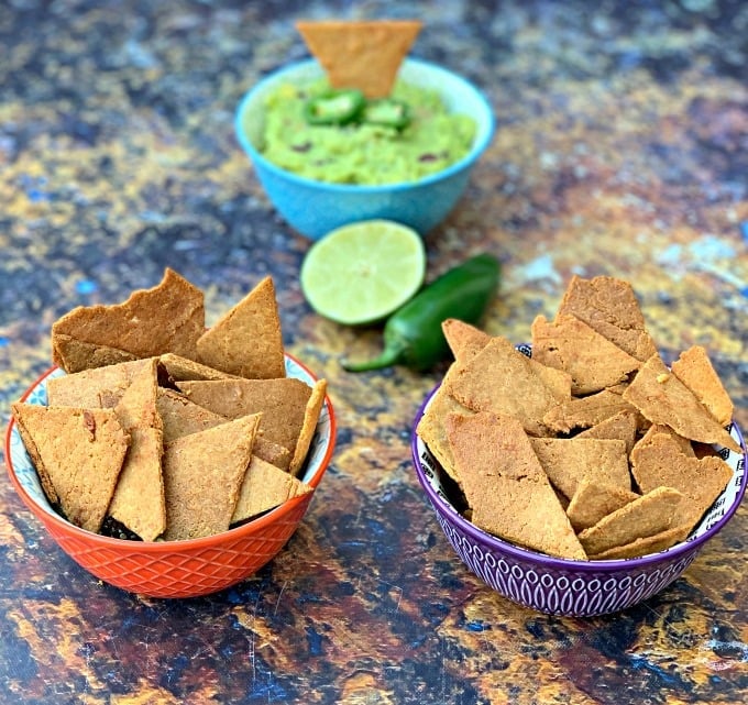 keto tortilla chips in bowls with guacamole and vegetables