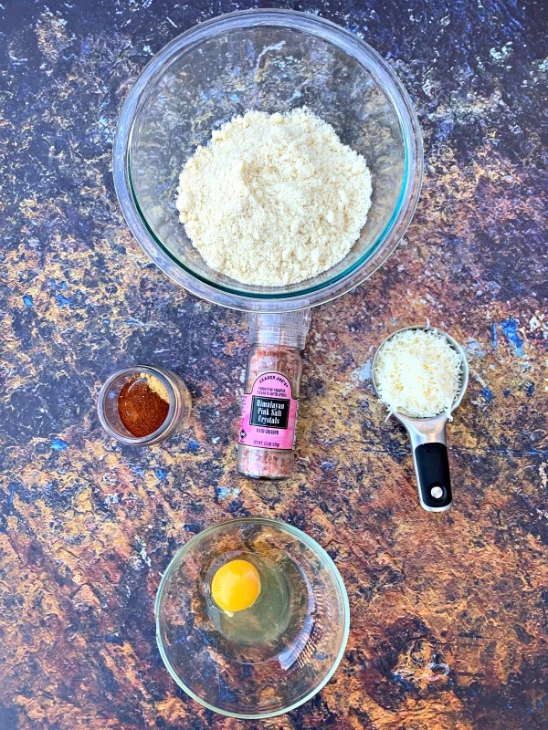 Keto Low-Carb Gluten-Free Homemade Tortilla Chips are a quick and easy recipe that uses a handful of ingredients. These crispy, crunchy chips are made with almond flour, Himalayan salt, and mozzarella and are practically no carb/carb free. You can also make crackers using the dough. The post also includes information on where to buy keto chips and what brands to look out for. #KetoRecipes #KetoTortillaChips ingredients for keto tortilla chips