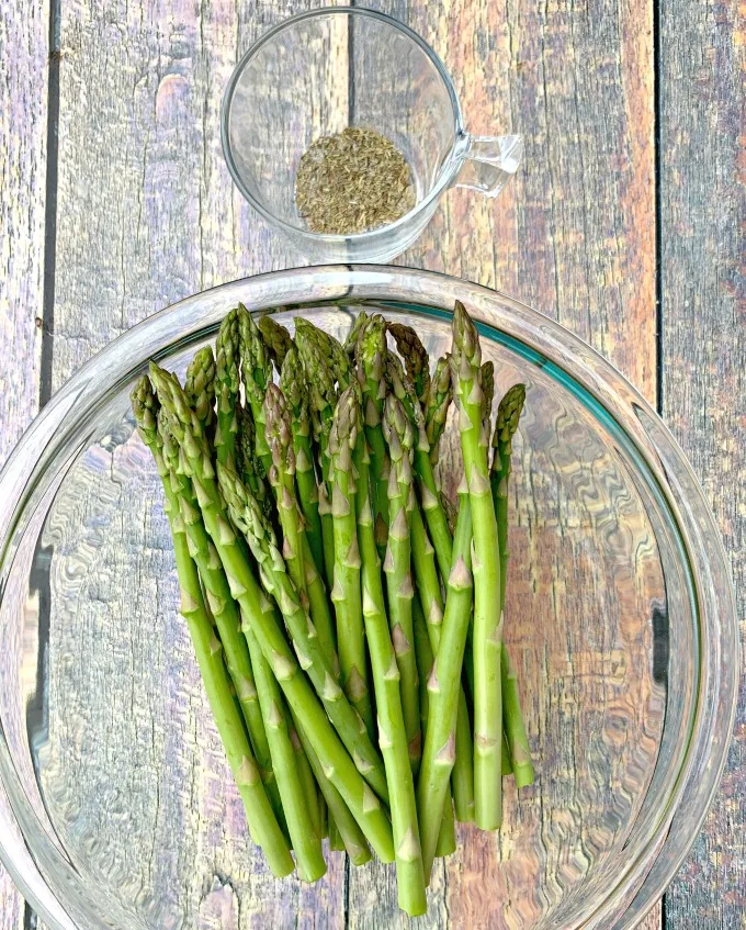 raw asparagus in a glass bowl