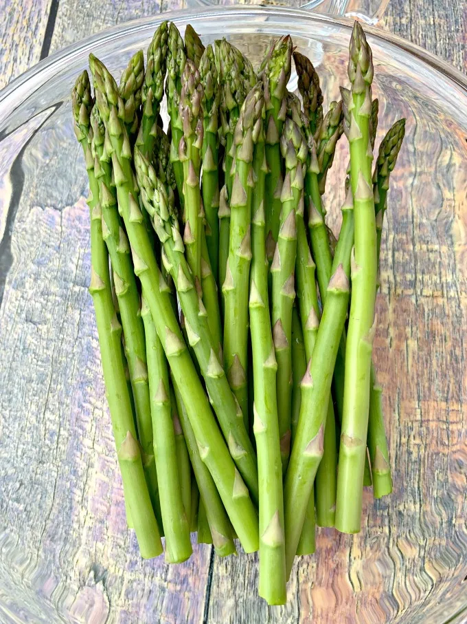 raw asparagus in a glass bowl