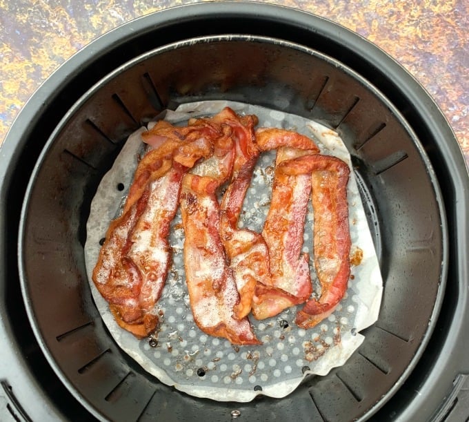 cooked bacon in an air fryer on parchment paper