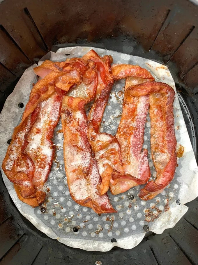 cooked bacon in an air fryer on parchment paper