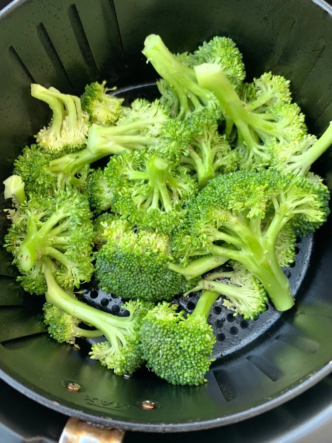 raw and cut broccoli in an air fryer