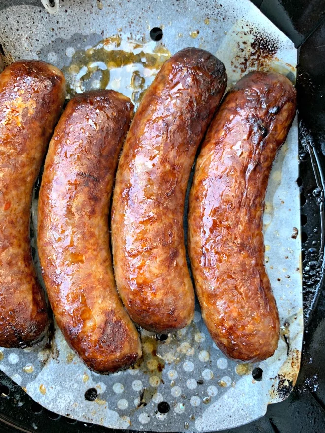 cooked air fryer sausage in an air fryer on parchment paper