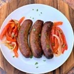cooked air fryer sausage on a plate with peppers