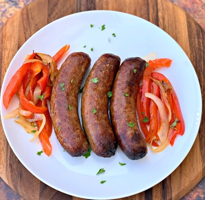 cooked air fryer sausage on a plate with peppers