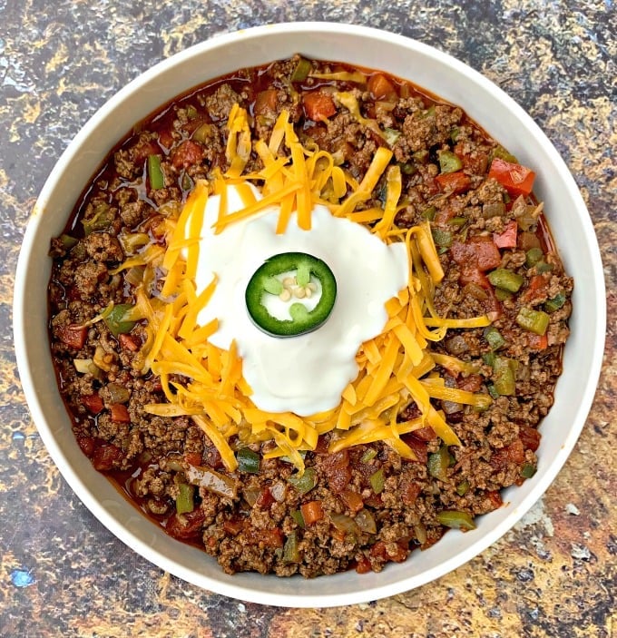 keto beef chili with shredded cheese in a white bowl