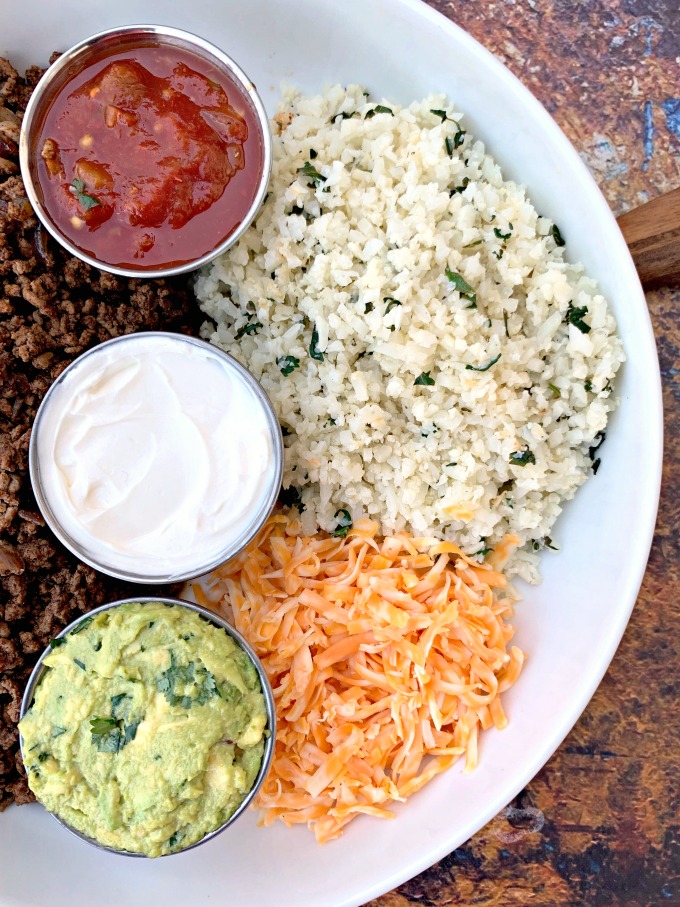 keto low carb tacos in a white bowl with cilantro lime cauliflower rice, salsa, guacamole, and salsa