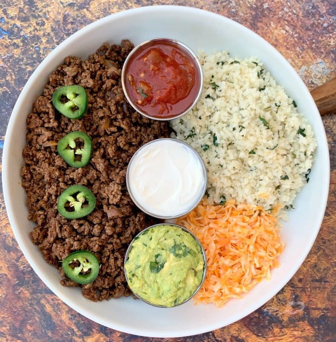 keto low carb tacos in a white bowl with cilantro lime cauliflower rice, salsa, guacamole, and salsa