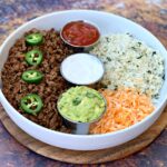 keto low carb tacos in a white bowl with cilantro lime cauliflower rice, salsa, guacamole, and salsa