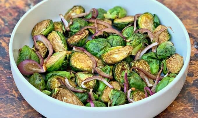 air fryer balsamic brussels sprouts with red onions in a white bowl