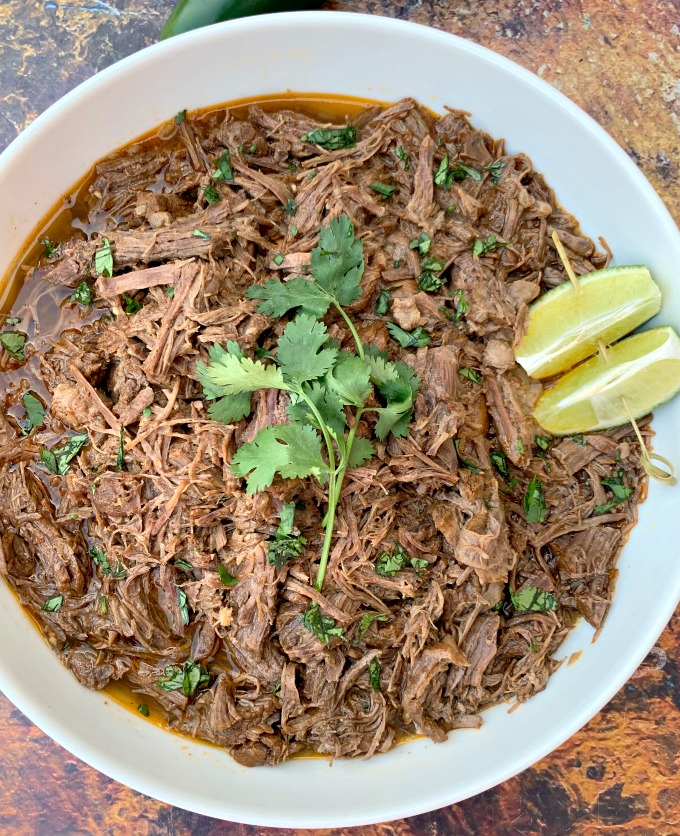 instant pot keto low carb barbacoa beef with cilantro and limes in a white bowl