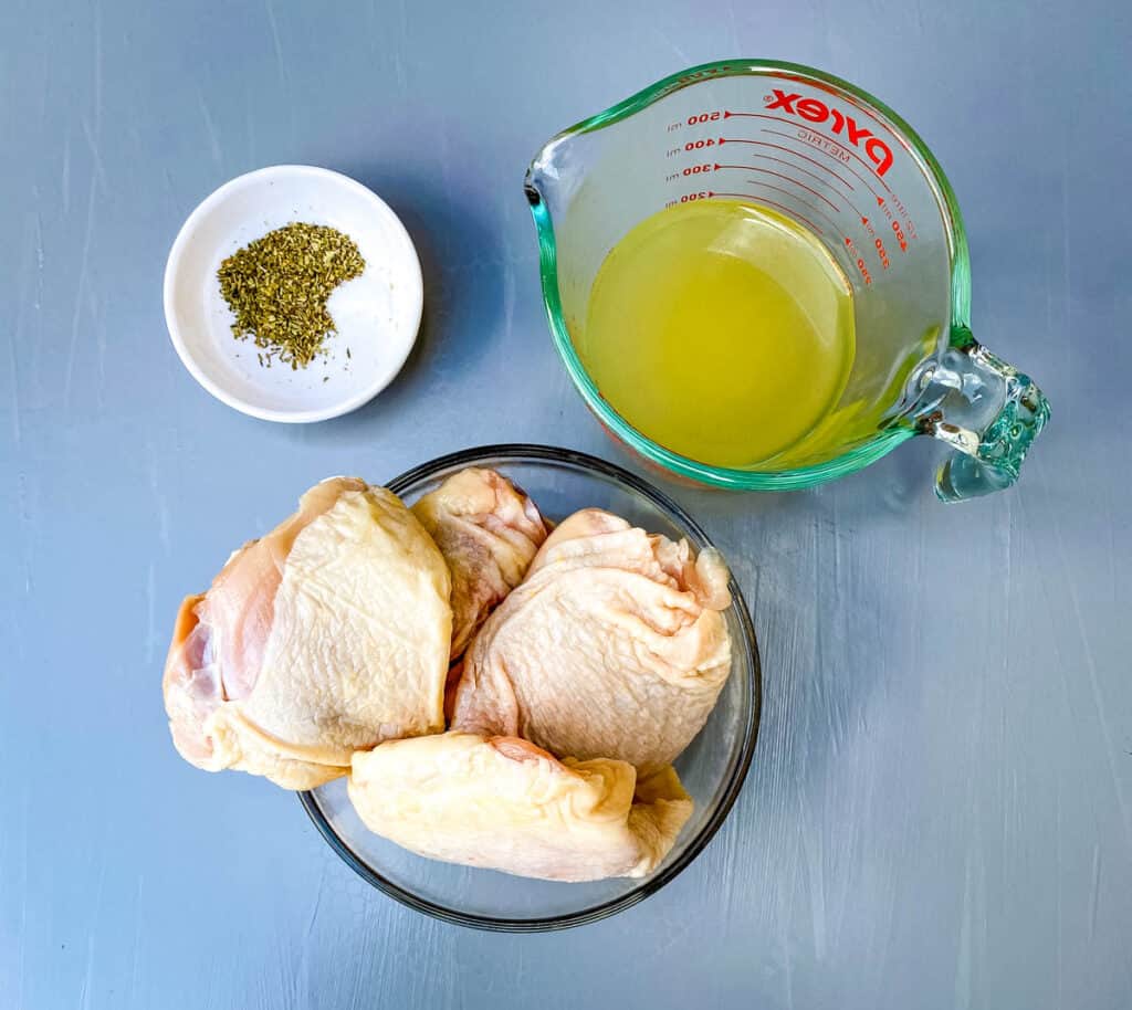 raw chicken thighs, chicken broth and Italian Seasoning in separate bowls