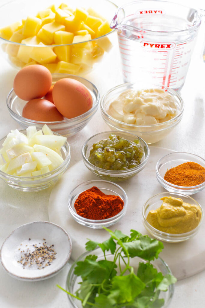 raw eggs, sliced potatoes, relish, mustard, and mayo in separate bowls