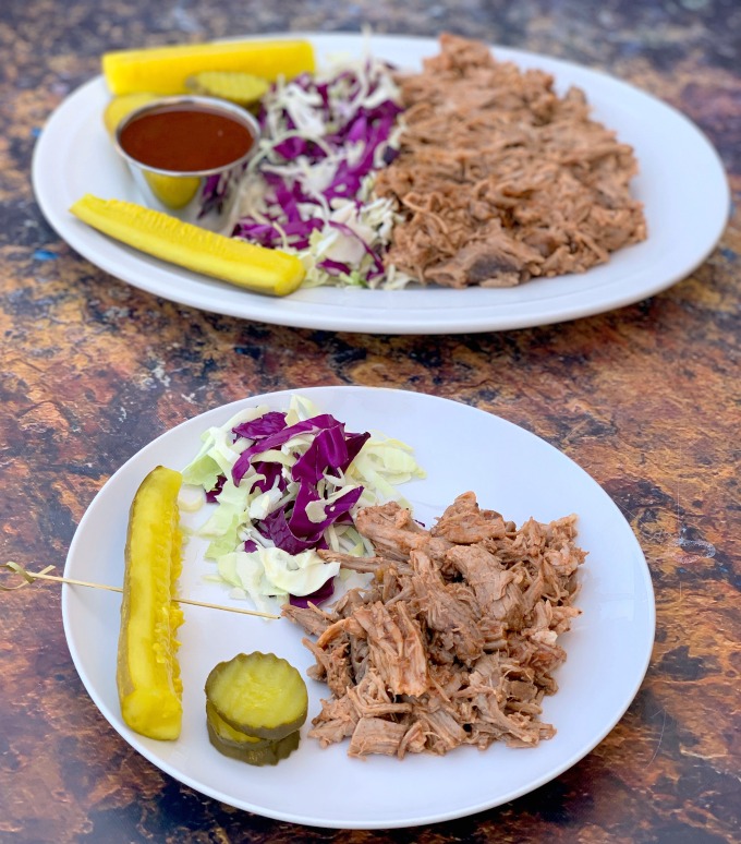 instant pot pulled pork on a plate with cabbage and pickles