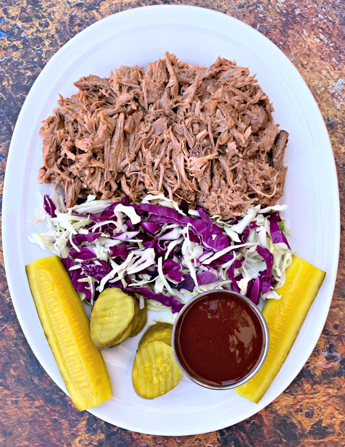 instant pot pulled pork on a plate with cabbage and pickles