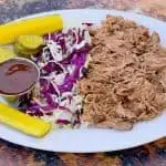 instant pot pulled pork on a plate with cabbage and pickles