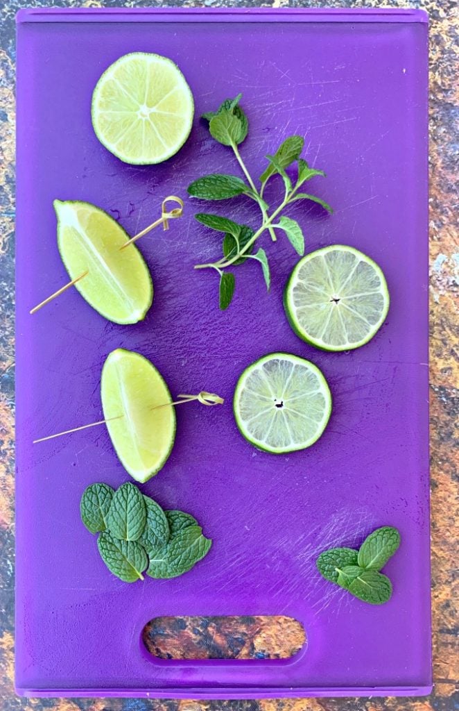 fresh limes and fresh mint on a purple cutitng board