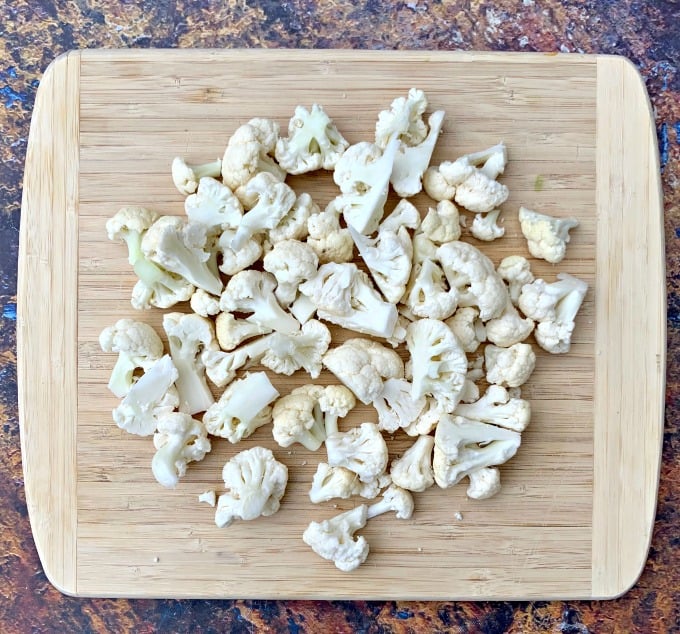 raw chopped cauliflower on a cutting board