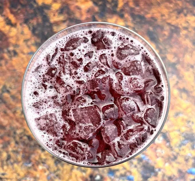 a close up shot of keto low carb red wine sangria in a wine glass with ice