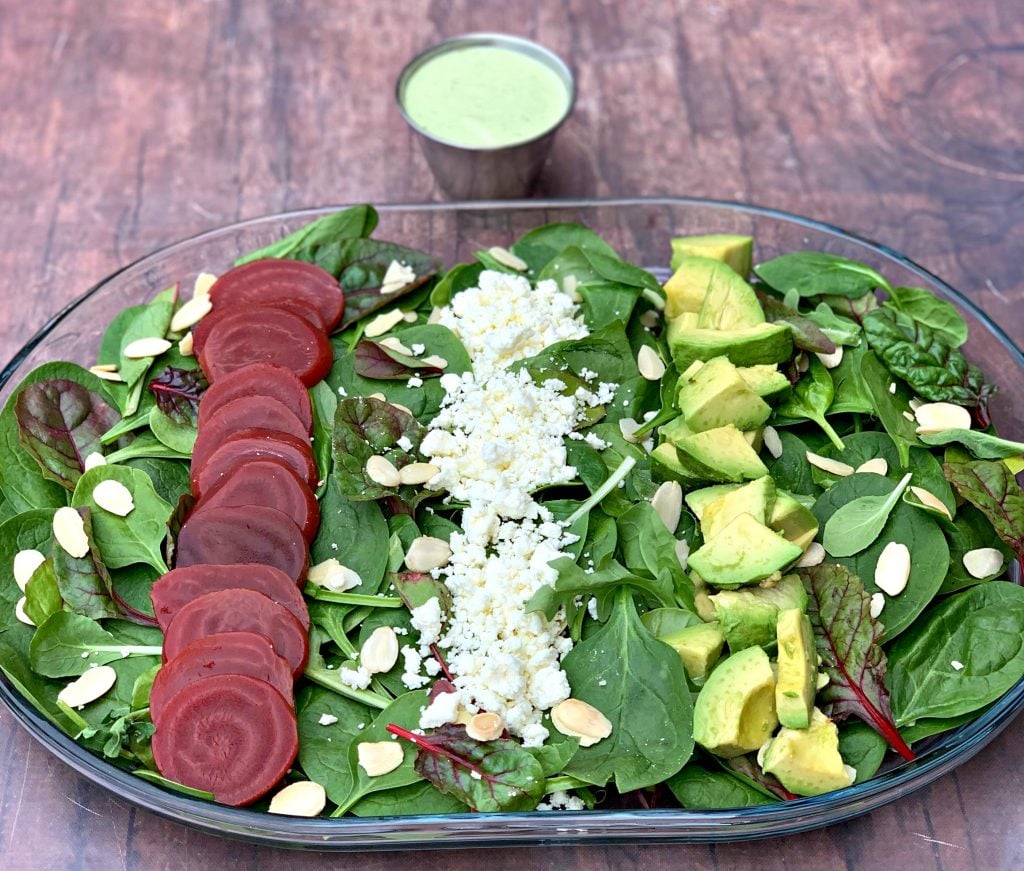 green goddess beet salad on a serving plate with dressing