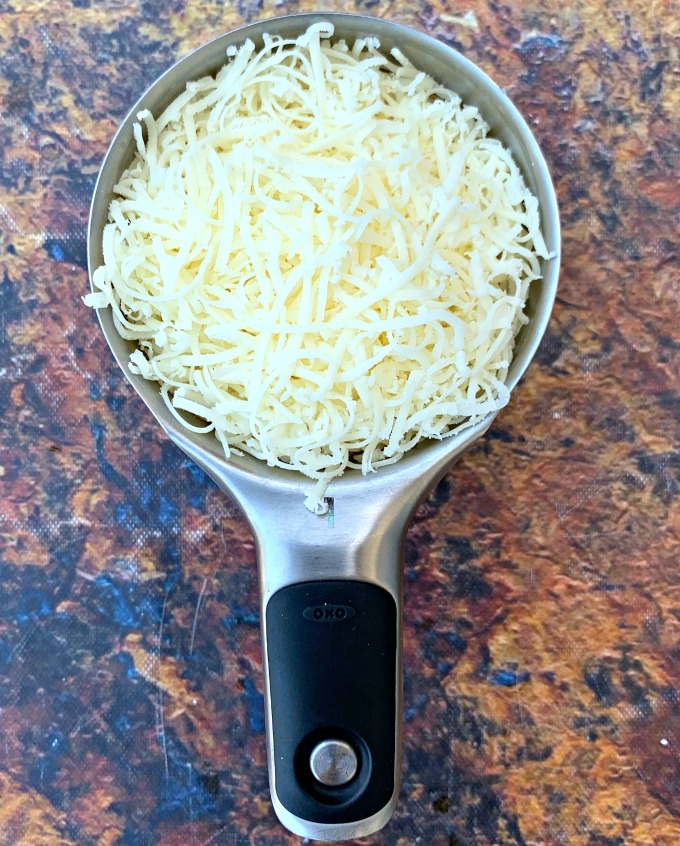 shredded mozzarella cheese in a measuring cup