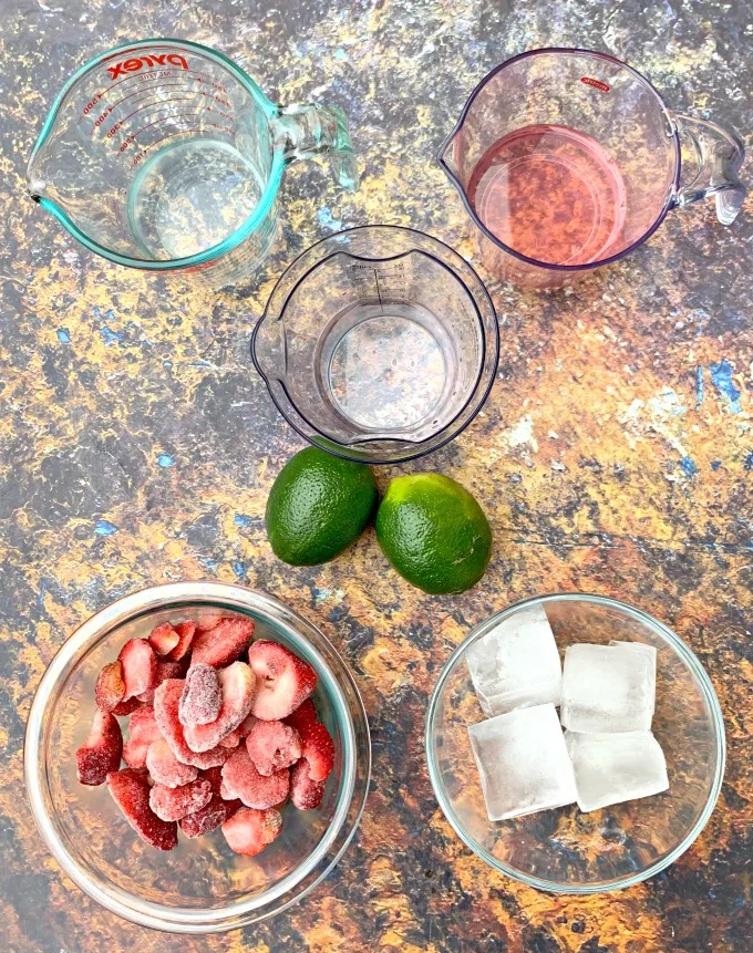 frozen strawberries, ice, fresh limes, club soda, tequila, and simple syrup in separate bowls