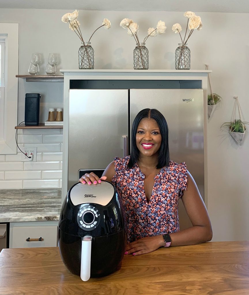 Brandi Crawford with an air fryer in a kitchen