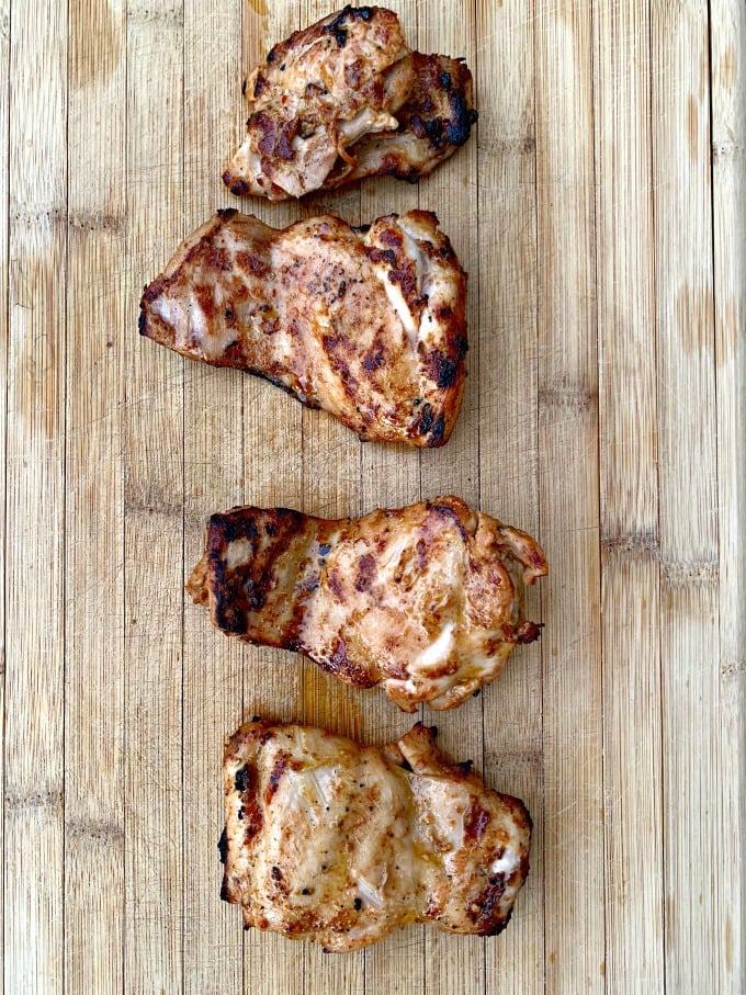 grilled chicken thighs on a cutting board