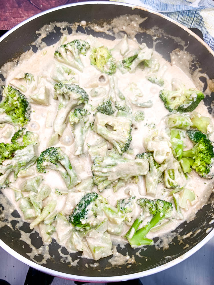 cream cheese and cooked broccoli in a skillet