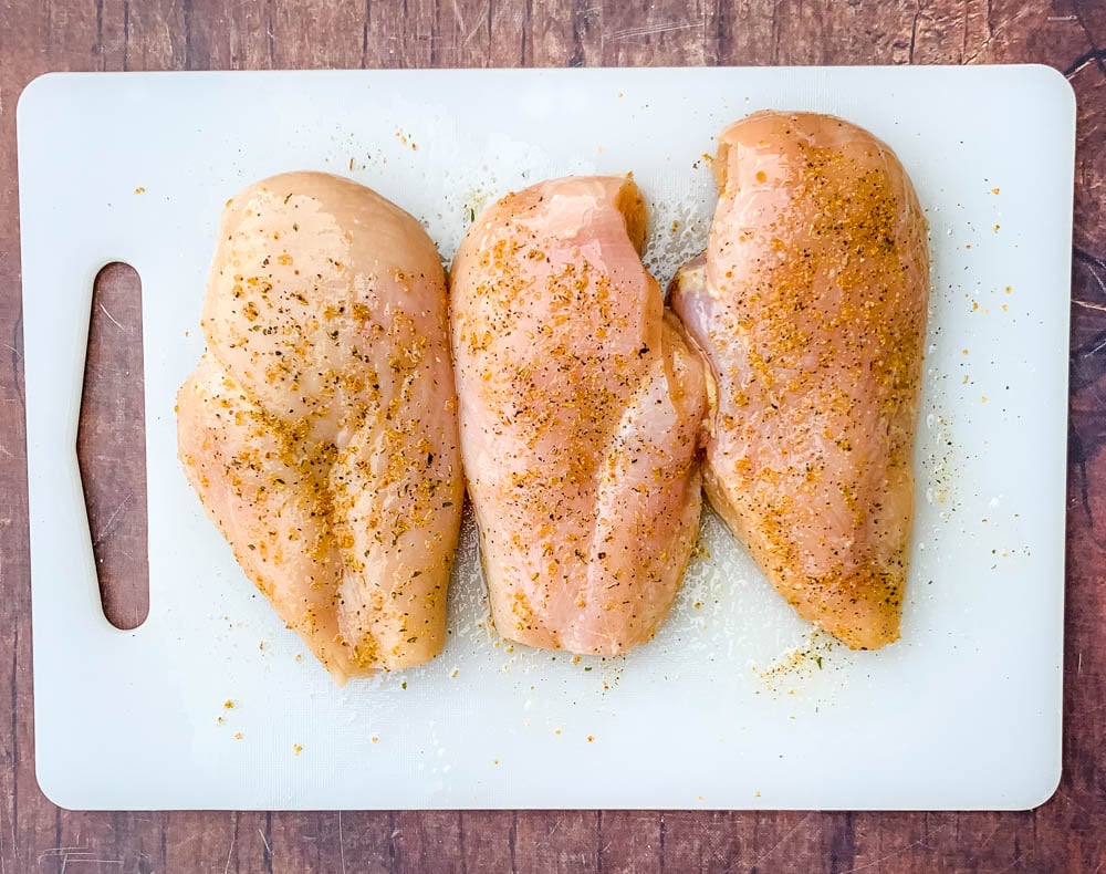 raw chicken breasts on a cutting board