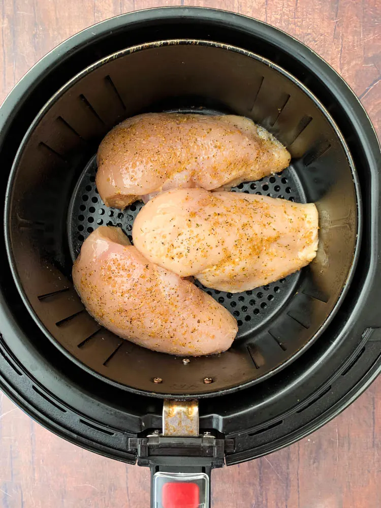 raw chicken breasts in an air fryer