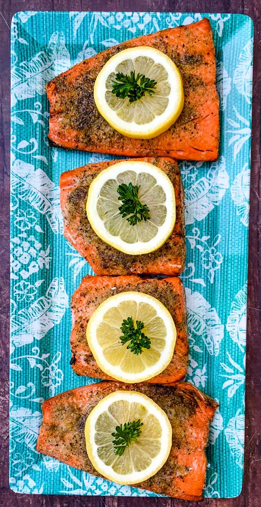 air fryer salmon on a blue plate with a fresh lemon size